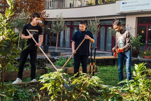 Ecole hôtelière Sainte-Thérèse -  Trois élèves s'occupent du jardin potager du restaurant d'application.